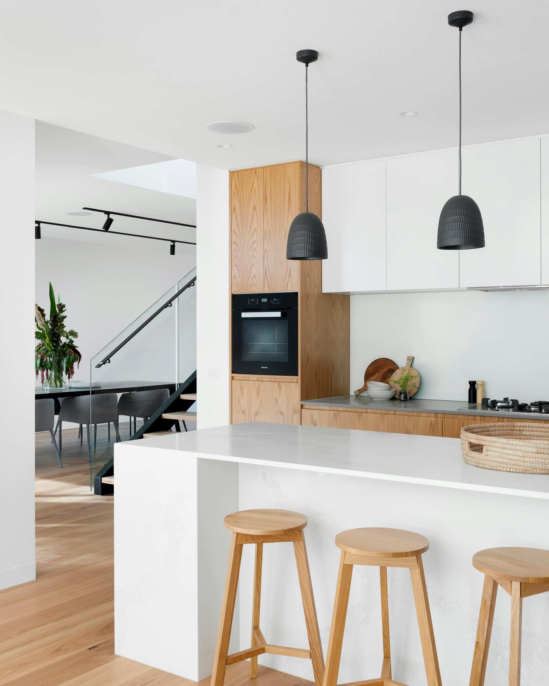 Bright kitchen with oak cabinetry, pendant lights and timber stools