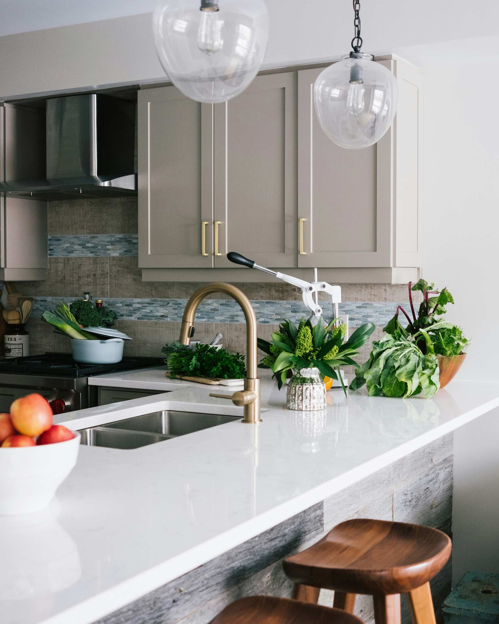 Brushed brass kitchen faucet over a white stone counter