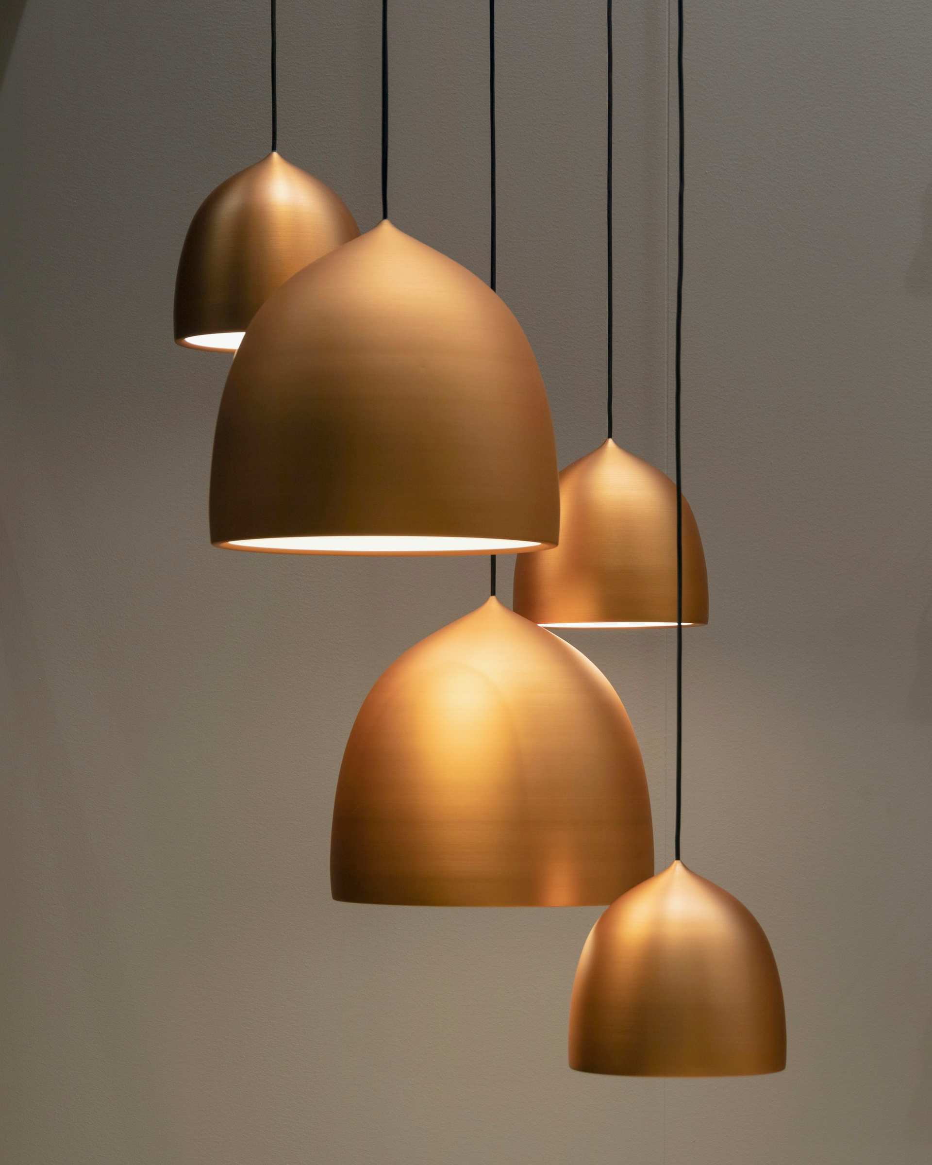 Three brass dome pendants hanging at staggered heights